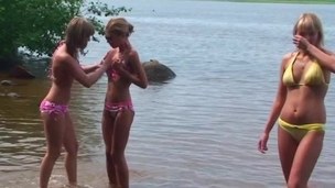 Several girls are getting in nature's garb at the beach in a hawt scene