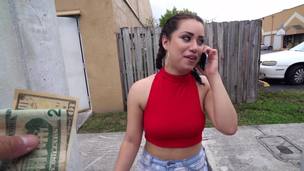 A brunette is given money to shake her ass in front of the camera