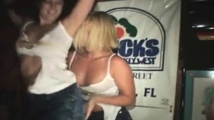 Striking girls giving a kiss and showing off their curves in the night club